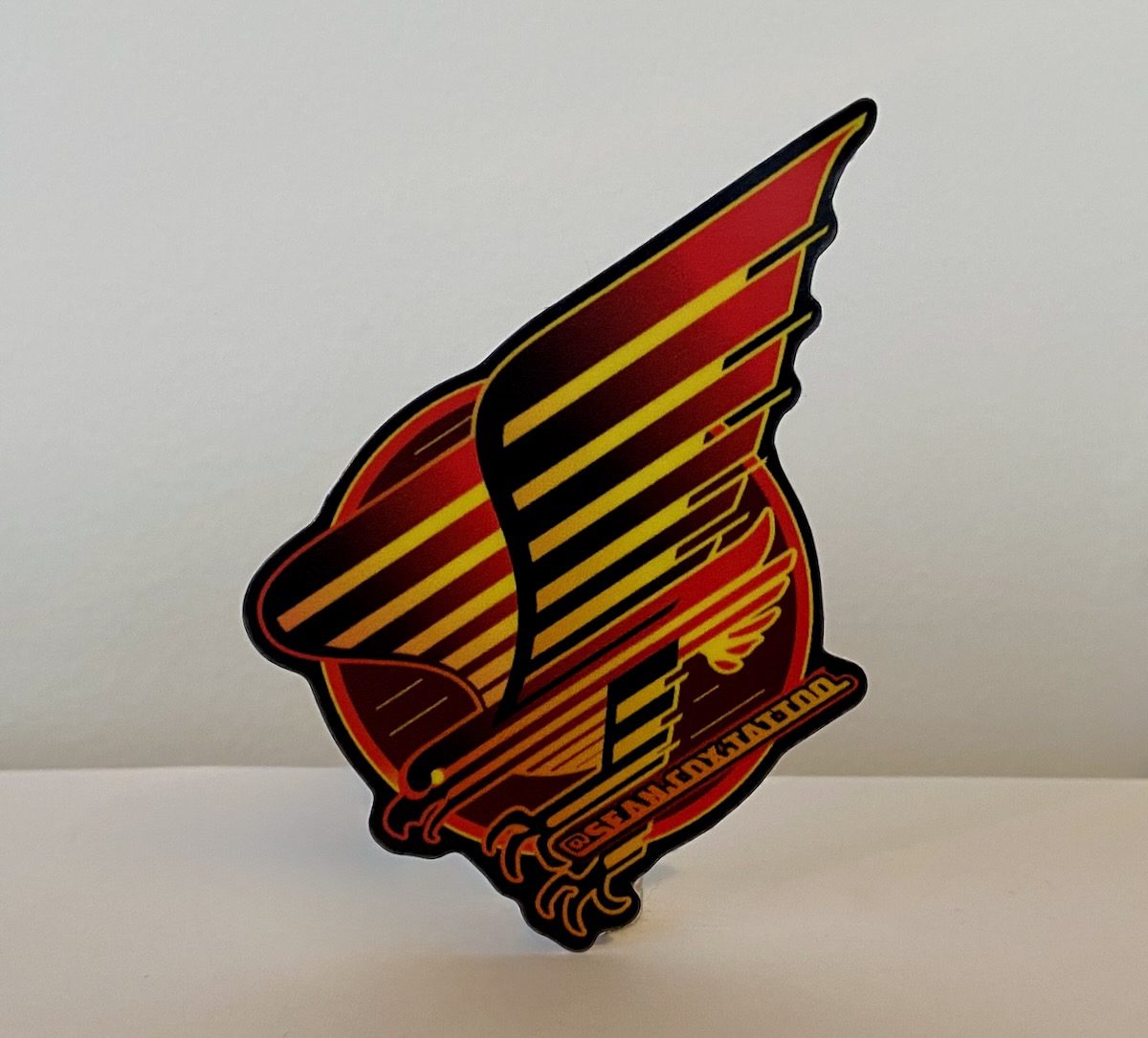 spaghetti-eagle-sticker-sean-cox-tattoo-new-westminster Red and yellow eagle sticker with spaghetti-stripe design
