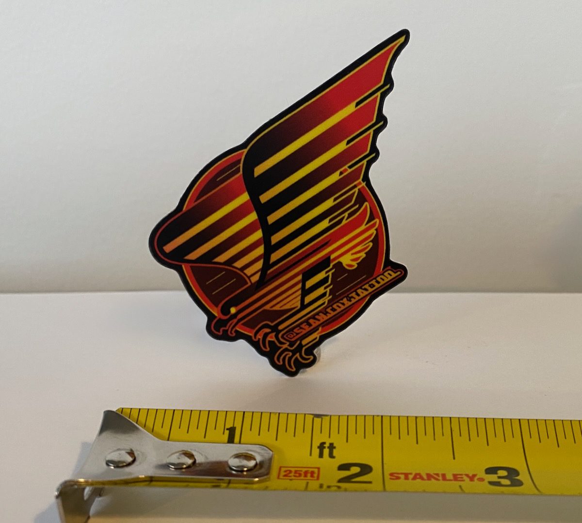 spaghetti-eagle-sticker-size-sean-cox-tattoo-new-westminster Spaghetti-stripe eagle sticker beside measuring tape