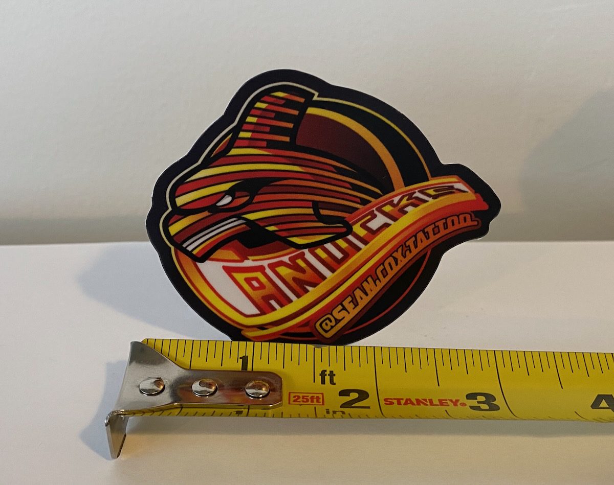 spaghetti-whale-sticker-size-sean-cox-tattoo-new-westminster Spaghetti-stripe whale sticker beside measuring tape