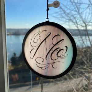 Hand-lettered “No” script artwork on round art glass