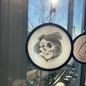 Grim reaper skull artwork on round art glass hanging
