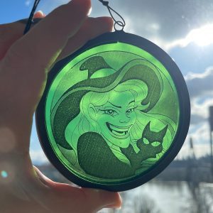 Green witch glass round held in front of sky
